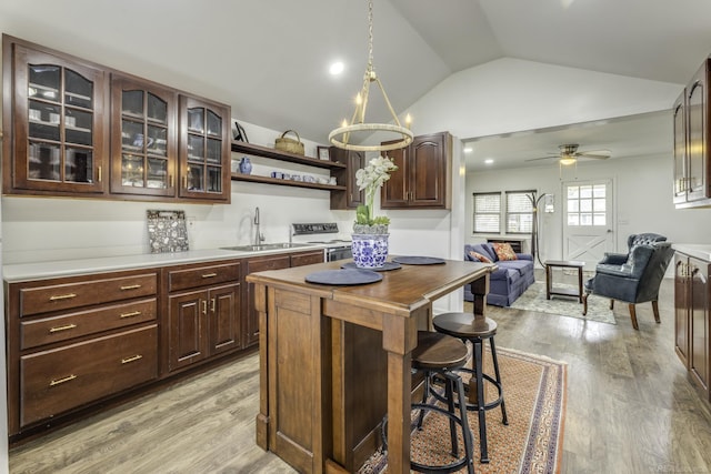 7173 Lake St, Lexington, MI 48450 - kitchen featuring range with electric cooktop, lofted ceiling, open shelves, a sink, and a breakfast bar