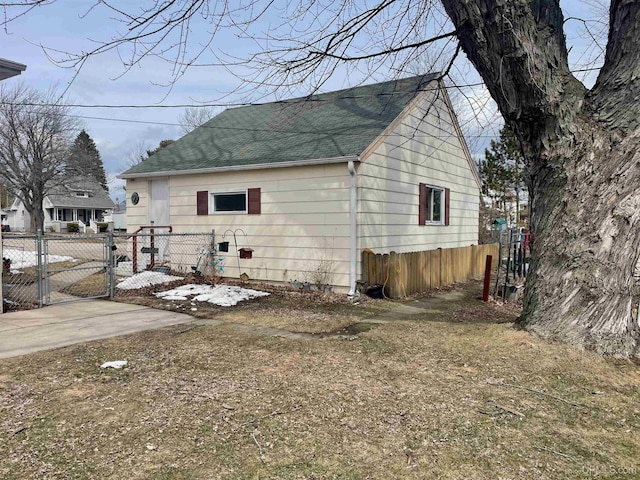 1215 Dakota Ave, Gladstone, MI 49837 - view of home's exterior featuring a shingled roof and a gate