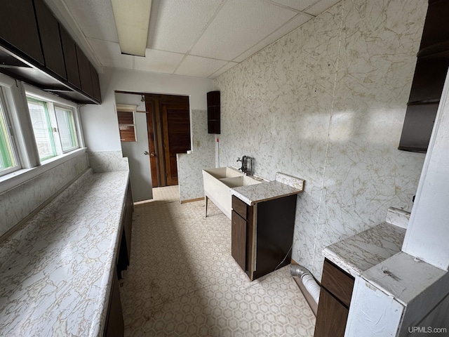 office space featuring a drop ceiling and light floors
