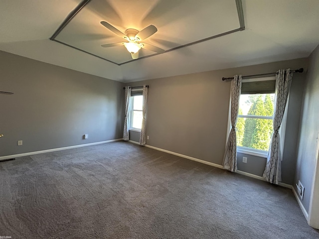 unfurnished room with dark colored carpet, baseboards, and ceiling fan