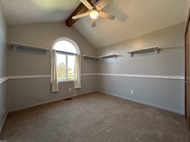 spare room featuring visible vents, baseboards, lofted ceiling with beams, a ceiling fan, and carpet