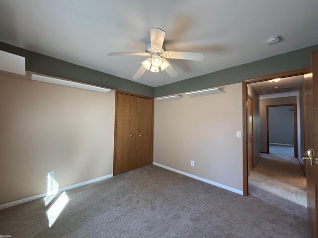 unfurnished bedroom with a closet, baseboards, a ceiling fan, and carpet