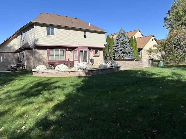 back of property featuring a yard and brick siding