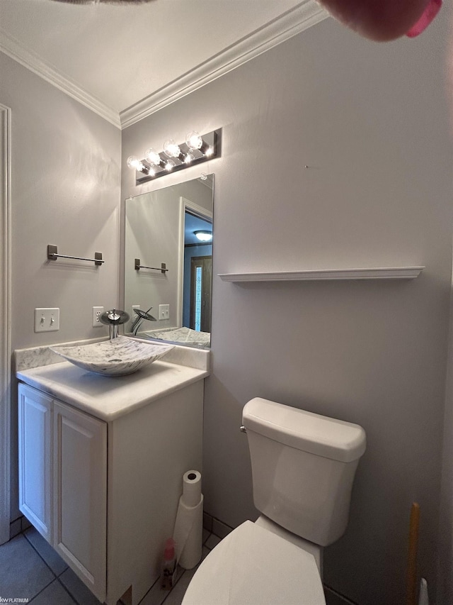 bathroom featuring toilet, tile patterned floors, vanity, and ornamental molding