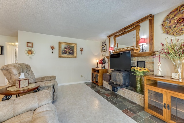 living area with visible vents, a wood stove, baseboards, and a textured ceiling