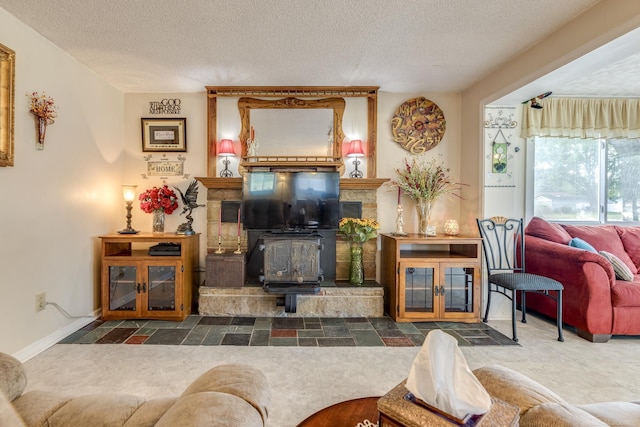 living room featuring a wood stove, a textured ceiling, and baseboards