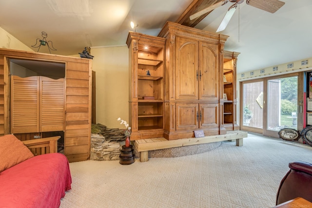 living area with carpet flooring, vaulted ceiling, and ceiling fan