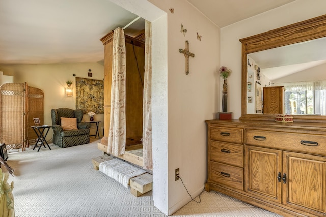 hallway featuring light carpet and lofted ceiling