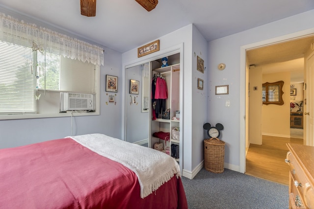 bedroom featuring ceiling fan, cooling unit, a closet, carpet floors, and baseboards