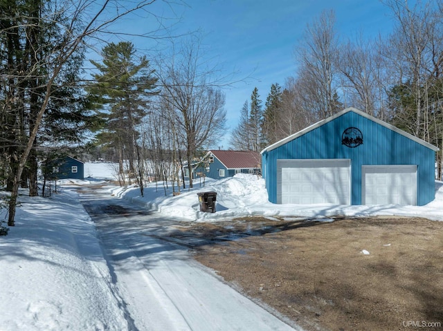 snow covered structure featuring an outbuilding