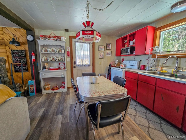 kitchen with stainless steel microwave, red cabinetry, open shelves, white electric range oven, and a sink