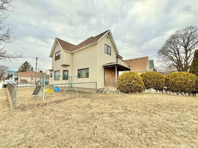 203 Stephenson Ave, Escanaba, MI 49829 - view of side of home featuring a playground and fence