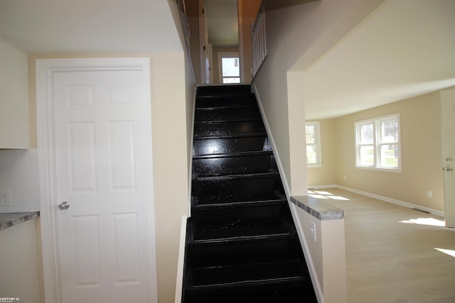 stairs featuring wood finished floors and baseboards