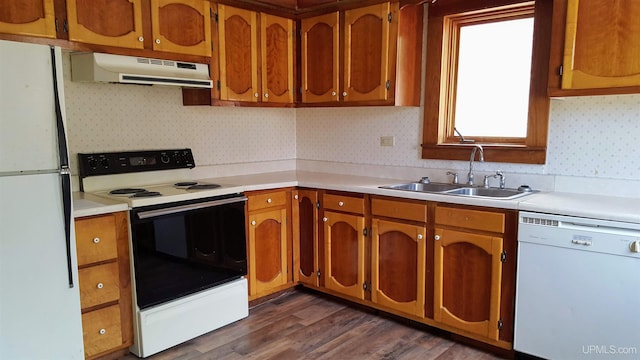 kitchen with range hood, a sink, light countertops, white appliances, and brown cabinetry