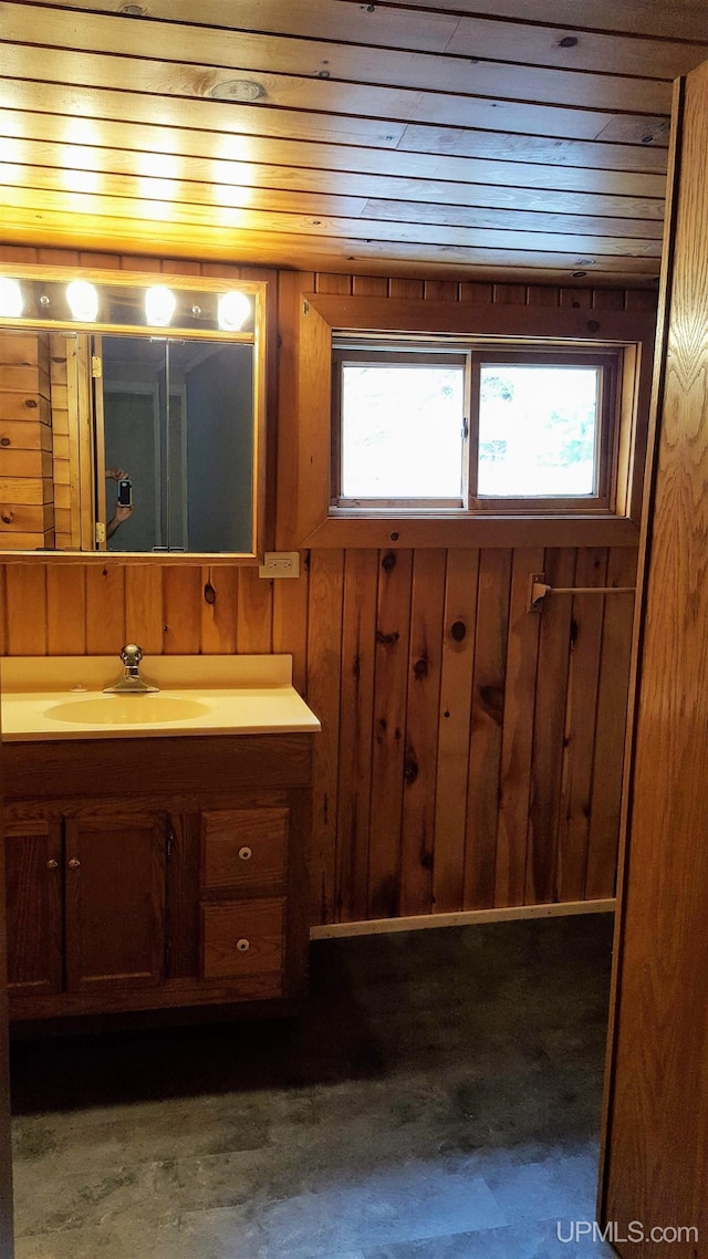 bathroom featuring wooden walls and vanity