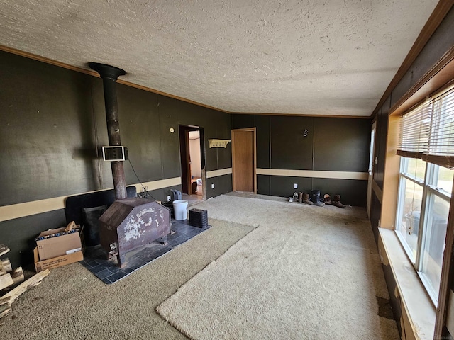 living area featuring a textured ceiling, a wood stove, and carpet flooring
