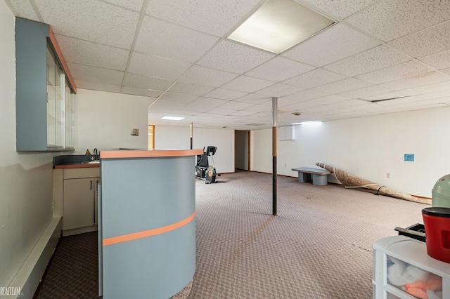 interior space featuring a sink, carpet floors, baseboards, and a paneled ceiling
