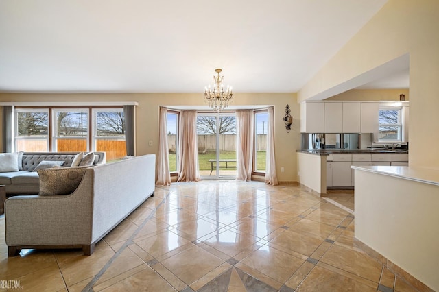 living room featuring a chandelier, light tile patterned floors, and baseboards