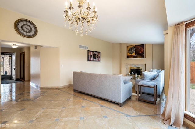 living room with a chandelier, a tile fireplace, visible vents, and baseboards