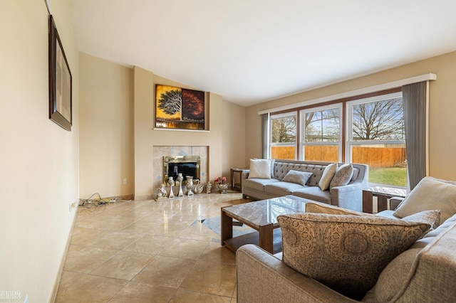living room with tile patterned flooring, a tile fireplace, and vaulted ceiling