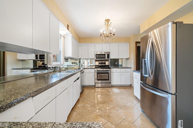 kitchen with a sink, white cabinets, a notable chandelier, and stainless steel appliances