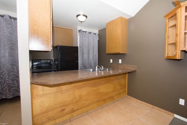 kitchen featuring baseboards, a sink, a peninsula, black appliances, and tile patterned floors