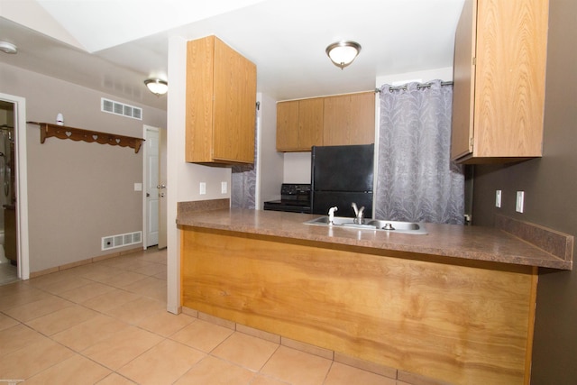 kitchen with visible vents, light tile patterned floors, a sink, a peninsula, and black appliances