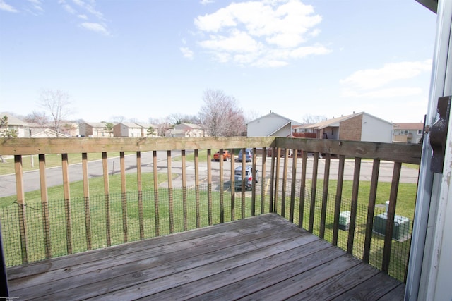 wooden terrace featuring a residential view and a lawn