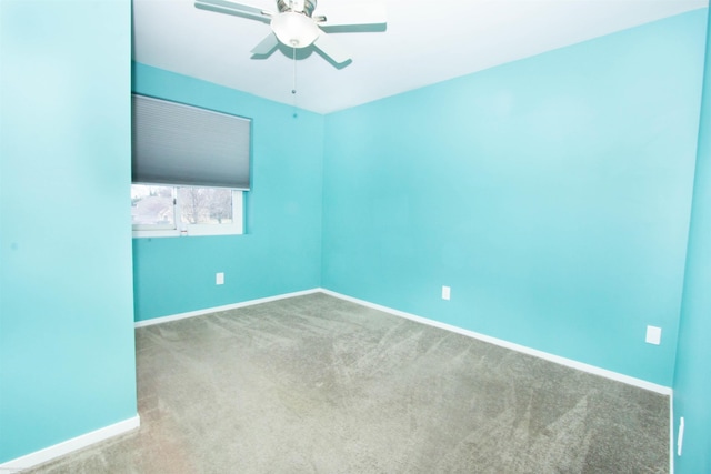 spare room with carpet floors, ceiling fan, and baseboards