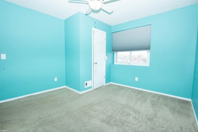 carpeted spare room featuring visible vents, baseboards, and a ceiling fan