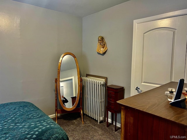 bedroom with radiator heating unit, baseboards, and dark carpet