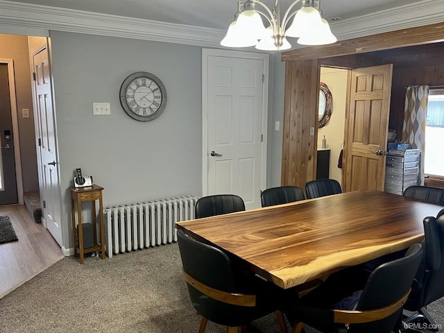 dining space featuring light colored carpet, radiator heating unit, a notable chandelier, and ornamental molding