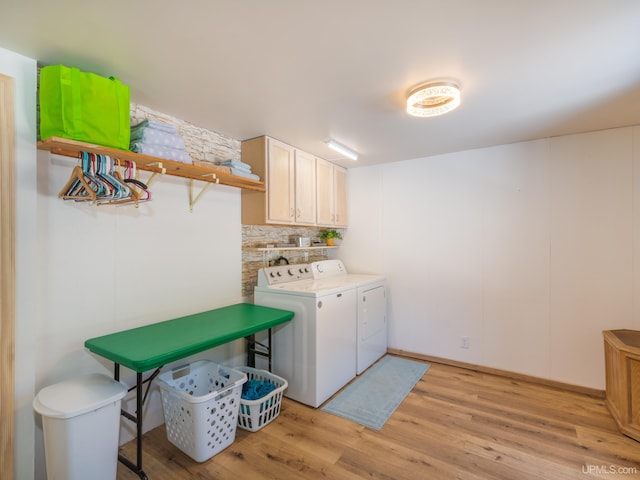 laundry room featuring light wood-style floors, washing machine and clothes dryer, and cabinet space
