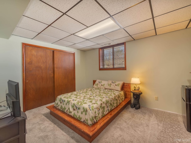 bedroom featuring a closet, carpet flooring, and a drop ceiling