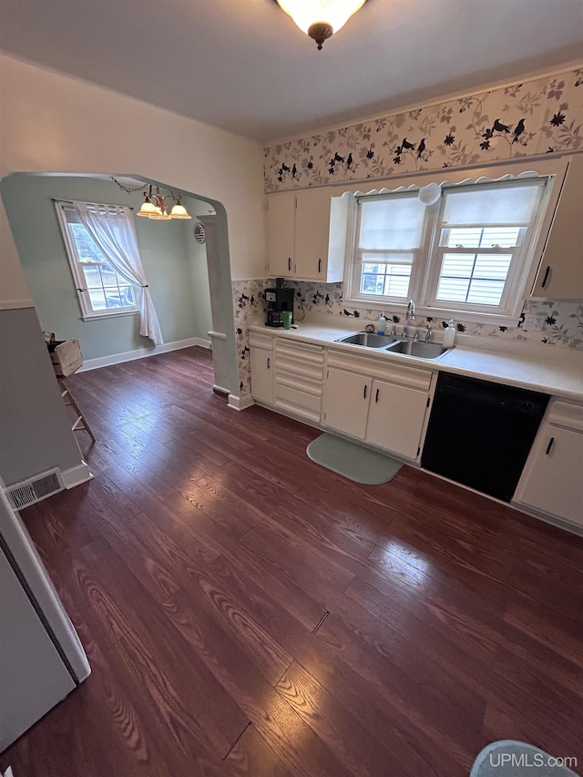 kitchen featuring visible vents, a healthy amount of sunlight, dishwasher, a sink, and dark wood-style flooring