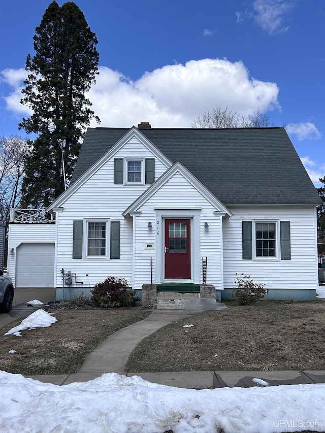 view of front of property featuring a garage, a chimney, and an outbuilding