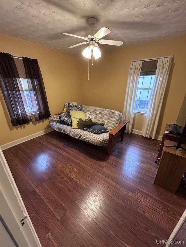 bedroom featuring ceiling fan, baseboards, and wood finished floors