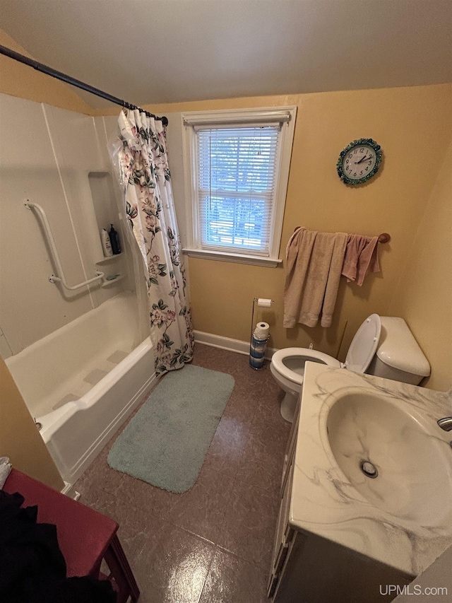 bathroom featuring a sink, shower / tub combo, toilet, and baseboards