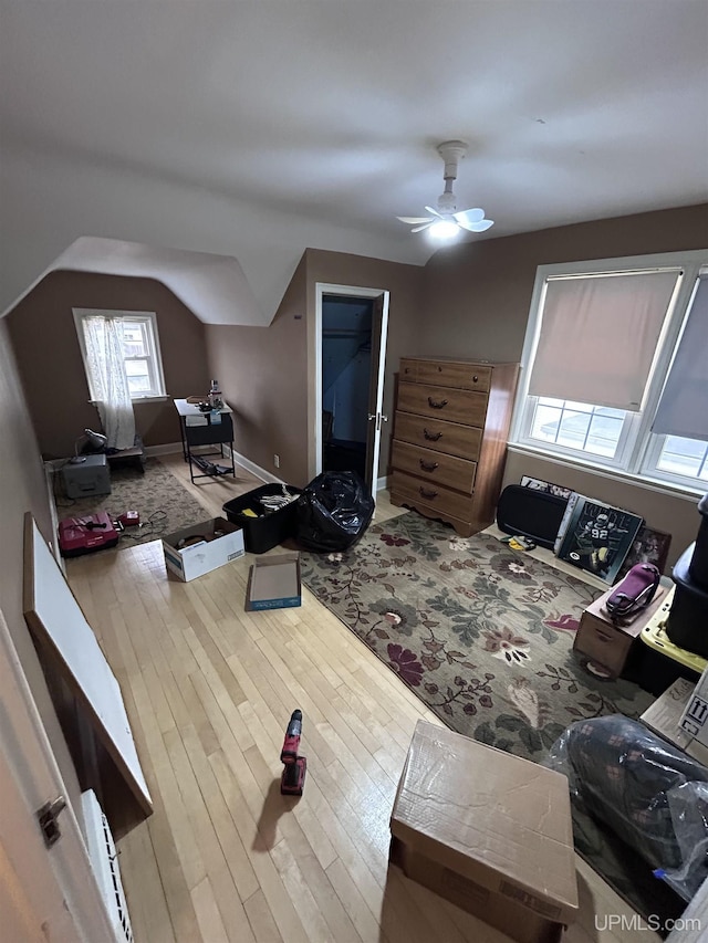 interior space with lofted ceiling, a ceiling fan, and wood finished floors