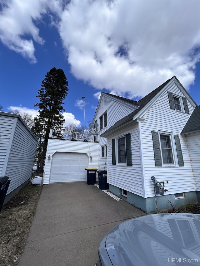 view of property exterior with an outbuilding and aphalt driveway