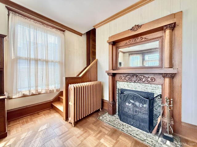 404 Lake Shore Dr, Escanaba, MI 49829 - detailed view of radiator, ornamental molding, a fireplace, and wooden walls