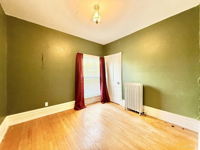 404 Lake Shore Dr, Escanaba, MI 49829 - unfurnished room with radiator heating unit, hardwood / wood-style flooring, and baseboards