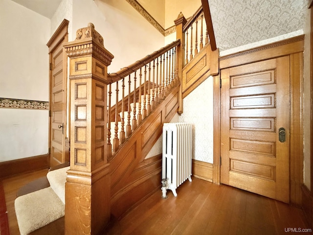 404 Lake Shore Dr, Escanaba, MI 49829 - stairs featuring radiator heating unit, wood-type flooring, and baseboards