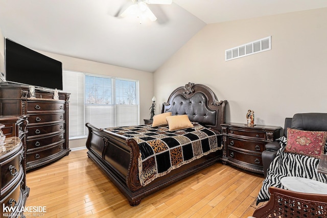 bedroom featuring light wood finished floors, visible vents, a ceiling fan, and lofted ceiling