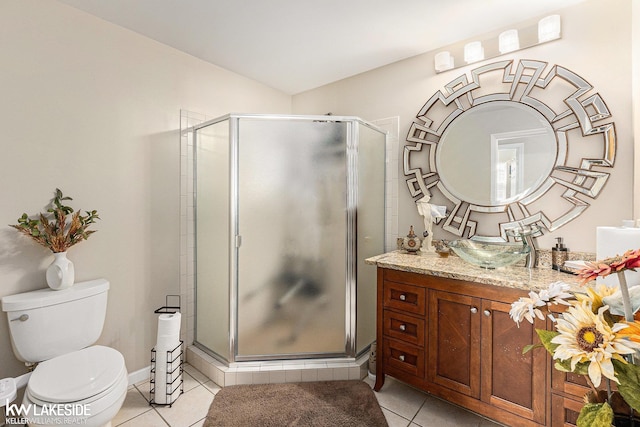 bathroom with toilet, tile patterned floors, vanity, and a stall shower