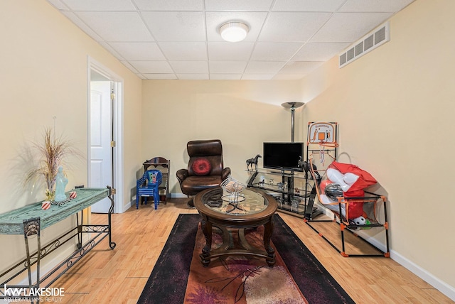 interior space featuring visible vents, baseboards, a drop ceiling, and wood finished floors