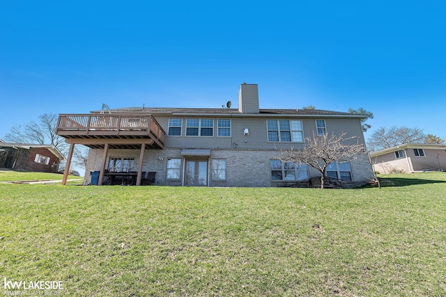 back of property featuring a deck, a lawn, and a chimney