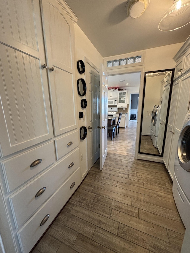 hall with dark wood-style floors and washing machine and clothes dryer