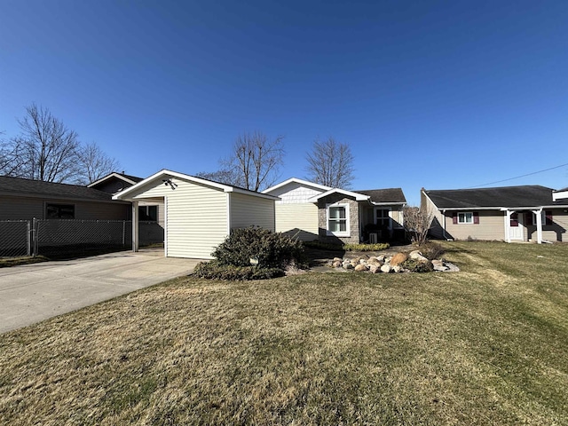 exterior space with driveway, fence, and a front lawn