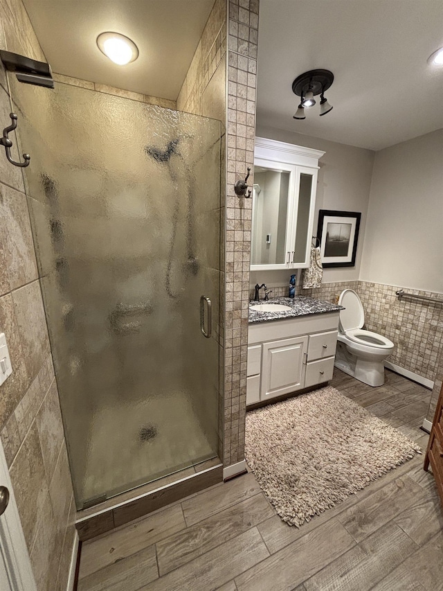 bathroom featuring vanity, tile walls, a stall shower, and wood tiled floor